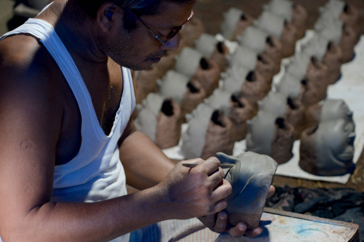 Seorang perajin mengerjakan wajah patung tanah liat dewi Hindu Durga di sebuah lokakarya menjelang festival Durga Puja di Vashi di Navi Mumbai, Kamis, 23 September 2021.