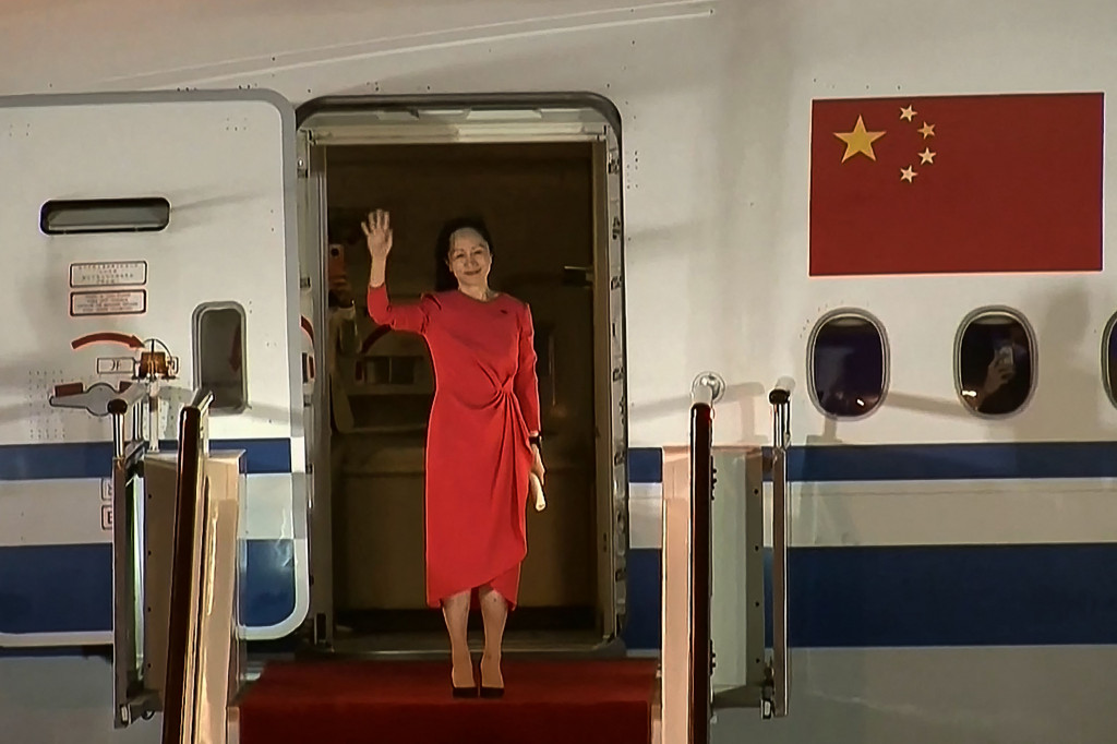 Meng Wanzhou melambaikan tangan kepada pendukungnya di Bandara Shenzen, 25 September 2021.