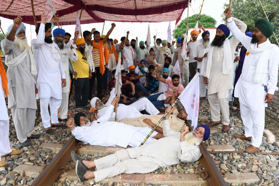 Para petani meneriakkan slogan-slogan sambil memblokir rel kereta api selama pemogokan nasional menentang reformasi pertanian pemerintah pusat di desa Devi Dasspura di pinggiran Amritsar pada 27 September 2021.