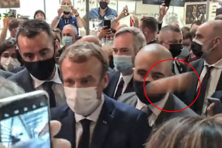Presiden Prancis Emmanuel Macron dilempar dengan sebutir telur (lingkaran merah) saat mengunjungi sebuah pameran perdagangan restoran dan hotel di kota tenggara Lyon pada hari Senin, 27 September 2021 waktu setempat. Telur yang dilemparkan seorang pria itu mengenai bahunya kemudian memantul tetapi tidak pecah.