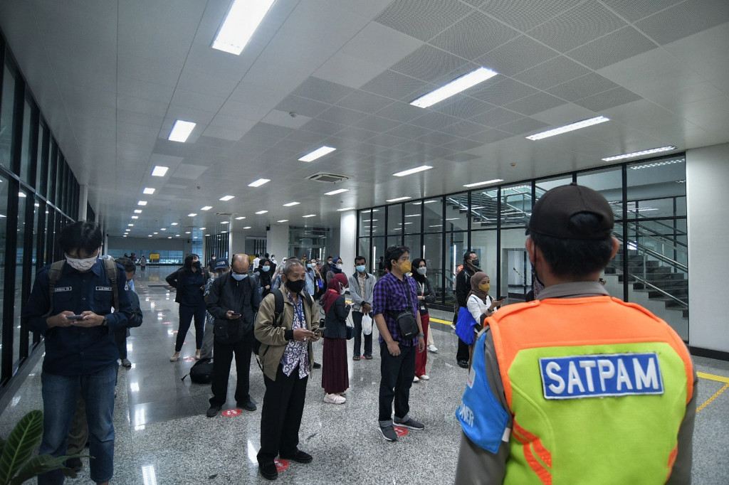 Calon penumpang antre sebelum menuju peron jalur layang (elevated track) di Stasiun Manggarai, Jakarta, Kamis, 30 September 2021.