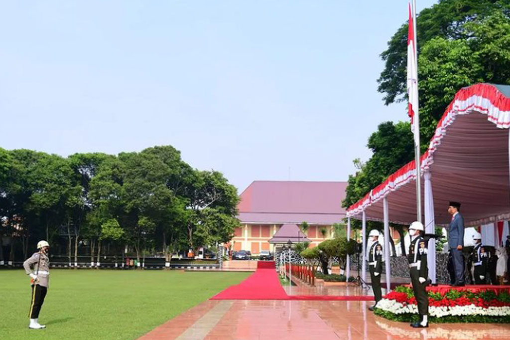 Presiden Jokowi hadir mengenakan jas abu-abu dengan dasi merah, kopiah hitam, dan mengenakan masker berwarna cokelat.