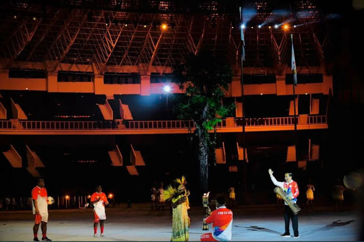 Boaz Solossa, sebagai pembawa obor PON terlihat memasuki lapangan untuk selanjutnya membawa obor tersebut ke arah kaldron yang berada di tengah lapangan untuk dinyalakan. 