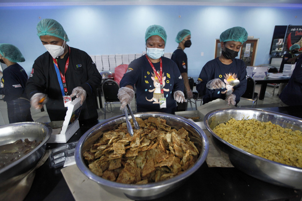 Pekerja Pangan Sari Utama (PSU) menyiapkan makanan bagi para atlet, ofisial serta tenaga pendukung Pekan Olahraga Nasional (PON) XX Papua di dapur penyangga di kawasan Sentani, Kabupaten Jayapura, Papua, Senin, 4 Oktober 2021.