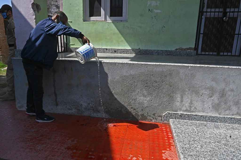 Seorang pria membersihkan noda darah di dalam sekolah yang dikelola pemerintah di pinggiran Srinagar pada Kamis, 7 Oktober 2021, setelah tersangka militan anti-India menembak mati dua guru.