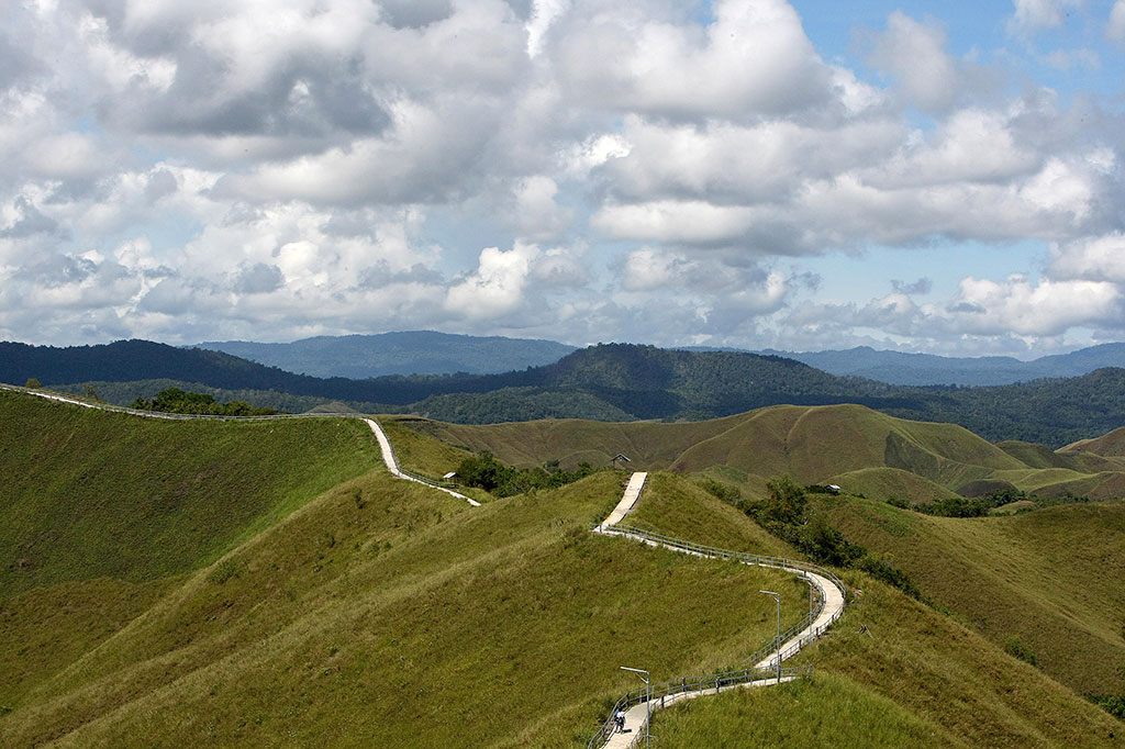 Dari situ Anda dapat melihat keindahan Danau Sentani. Namun, jika Anda mau mengeluarkan sedikit energi untuk menaiki anak tangga, Anda dapat melihat indahnya deretan bukit warna hijau yang dipadukan dengan birunya Danau Sentani.