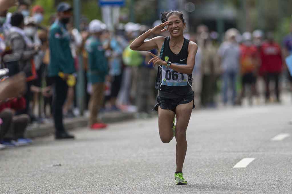 Atlet DKI Jakarta Odekta Elvina Naibaho melakukan hormat saat akan finis dalam nomor lari maraton putrI PON Papua di kompleks Freeport, Kuala Kencana, Kabupaten Mimika, Papua, Sabtu, 9 Oktober 2021.