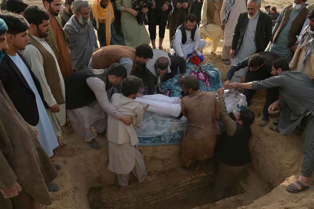 Para pelayat dari komunitas minoritas Syiah Afghanistan memakamkan jenazah korban serangan bom bunuh diri di sebuah masjid, Sabtu, 9 Oktober 2021. Bom bunuh diri yang diklaim oleh kelompok Negara Islam ISIS-K tersebut mengakibatkan lebih dari 60 orang meninggal dunia.