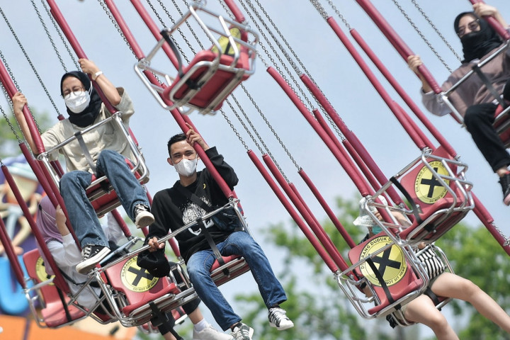 Pengunjung saat menaiki wahana ontang anting di Dunia Fantasi, Ancol, Jakarta, Minggu, 10 Oktober 2021. Meredanya kasus Covid-19 di Jakarta membuat sejumlah tempat wisata kembali ramai didatangi pengunjung. 
