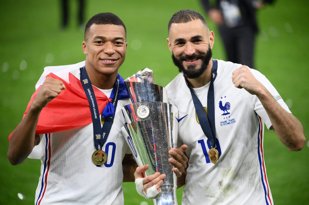 Kylian Mbappe (kiri) dan Karim Benzema (kanan) memegang trofi kemenangan usai mengalahkan Spanyol pada laga final UEA Nations League 2021.