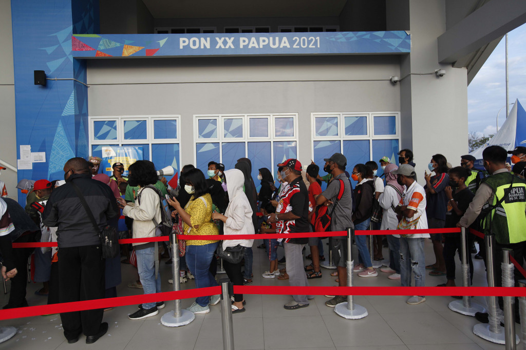 Antrean panjang masyarakat yang akan menonton pertandingan di Venue Aquatik di Kompleks Olahraga Kampung Harapan, Kabupaten Jayapura, Papua, Senin, 11 Oktober 2021.