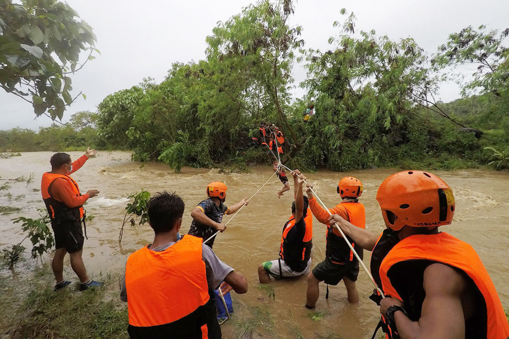 Tim penyelamat mengevakuasi warga dari rumah mereka di dekat sungai yang meluap akibat hujan deras yang disebabkan oleh Badai Tropis Kompasu di Kota Gonzaga, Provinsi Cagayan, utara Manila.