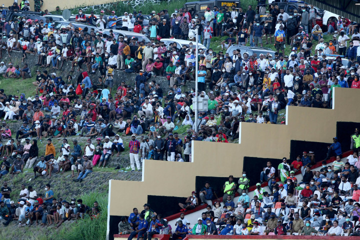 Para penonton yang tidak kebagian tiket masuk menonton dari luar lapangan saat pertandingan Semifinal Sepak Bola Putra PON Papua di Stadion Mandala, Kota Jayapura, Papua, Selasa, 12 Oktober 2021.