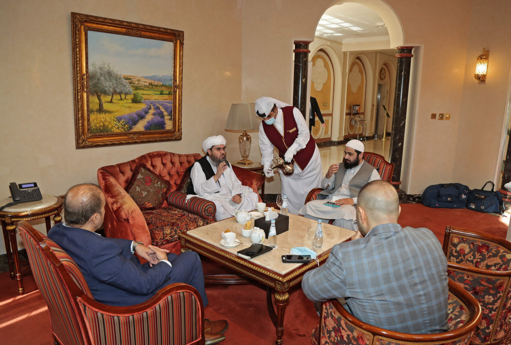 Mantan utusan Taliban untuk Arab Saudi Shahabuddin Delawar (tengah) meminum kopi sebelum pertemuan dengan diplomat asing di Doha, Qatar, Selasa, 12 Oktober 2021.