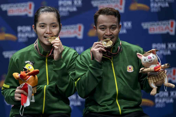 Pasangan Jawa Timur Rehan Naufal Kusharjanto dan Marheilla Gischa Islami berpose dengan medali emasnya usai memenangi pertandingan final Bulu Tangkis Ganda Campuran PON Papua di GOR Waringin Kotaraja, Kota Jayapura, Papua, Rabu, 13 Oktober 2021.