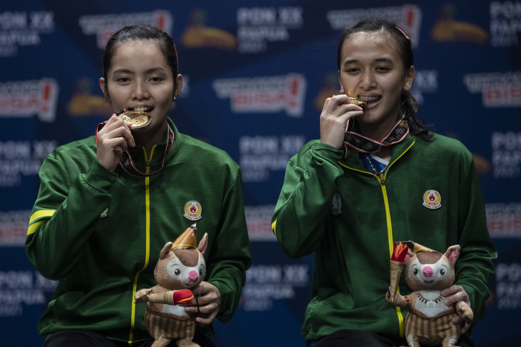 Pebulu tangkis ganda putri Jawa Timur Febriana Dwi Puji Kusuma dan Marsheilla Gischa Islami berpose dengan medali emasnya usai pertandingan final ganda putri PON Papua di GOR Waringin Kotaraja, Kota Jayapura, Papua, Rabu, 13 Oktober 2021.