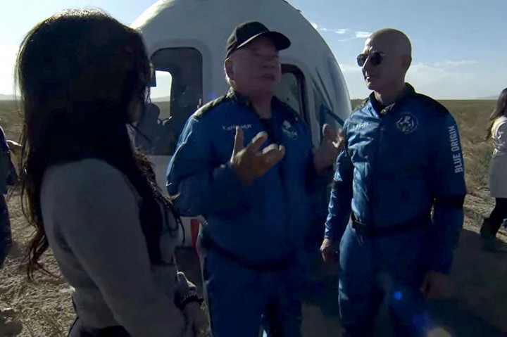 Aktor Star Trek, William Shatner (tengah) berbincang dengan pendiri Blue Origin Jeff Bezos setelah mendarat di wilayah Texas Barat, 25 mil (40kms) utara Van Horn, Rabu, 13 Oktober 2021 waktu setempat.