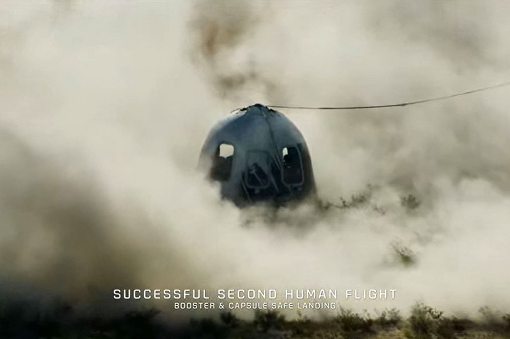 Pendiri Jeff Bezos berada di landasan untuk menyambut anggota kru saat mereka turun dari kapsul, yang mendarat dengan parasut di padang pasir, dan disambut tepuk tangan dan sampanye.