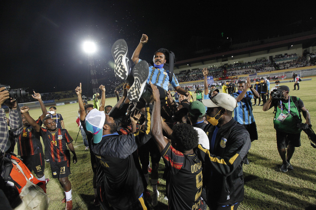 Pelatih tim sepak bola Papua Eduard Ivakdalam (tengah) dikelilingi para pemain merayakan kemenangan dalam pertandingan Final Sepak Bola Putra PON Papua di Stadion Mandala, Kota Jayapura, Papua, Kamis, 14 Oktober 2021, malam.