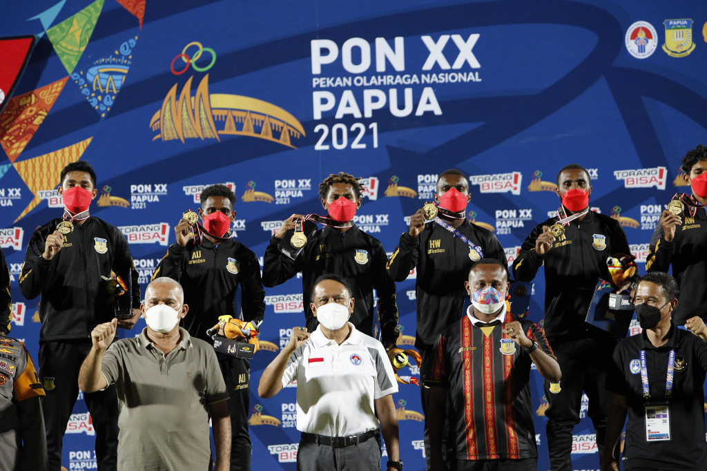 Menteri Olahraga Zainuddin Amali (tengah) dengan anggota Komisi I Yan Mandenas (kedua kanan) berfoto bersama para pemain sepak bola Papua dalam pertandingan Final Sepak Bola Putra PON Papua di Stadion Mandala, Kota Jayapura, Papua, Kamis, 14 Oktober 2021, malam.