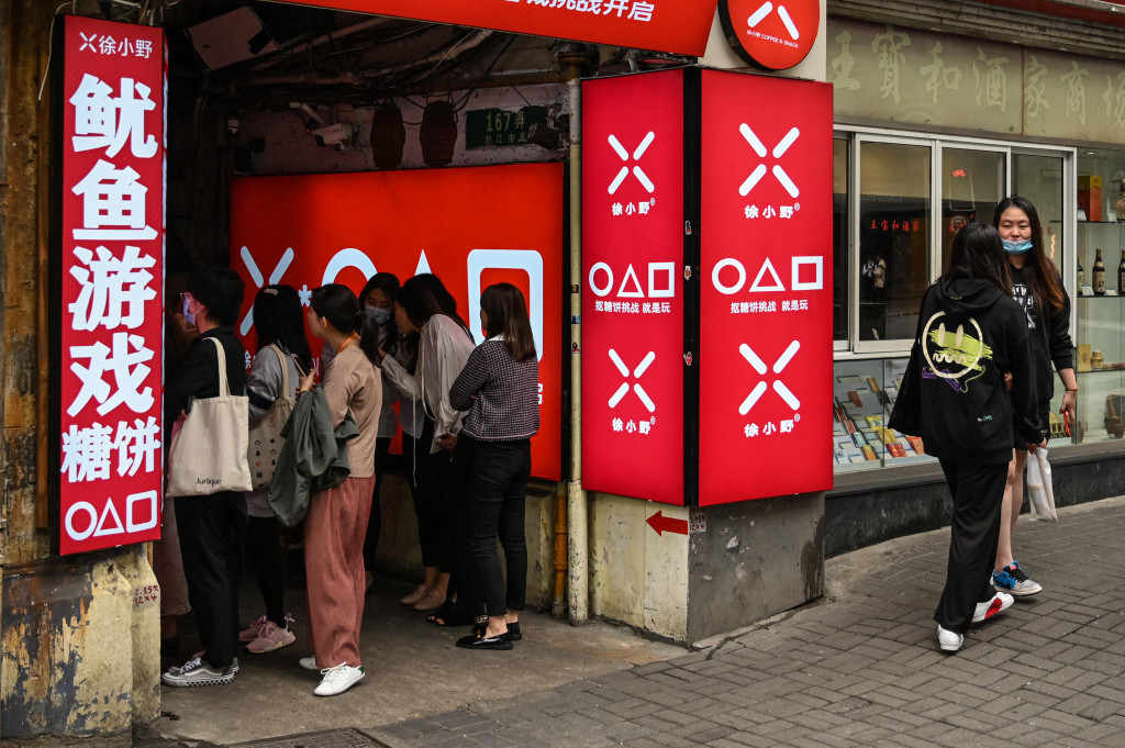 Pelanggan menunggu di toko kecil untuk dalgona, permen gula renyah yang ditampilkan dalam serial Netflix, Squid Game, di Shanghai, pada 12 Oktober 2021.