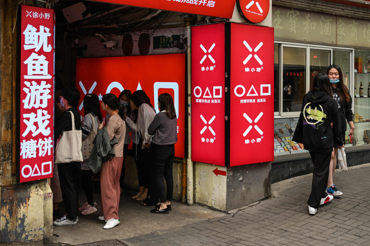 Pelanggan menunggu di toko kecil untuk dalgona, permen gula renyah yang ditampilkan dalam serial Netflix, Squid Game, di Shanghai, pada 12 Oktober 2021.