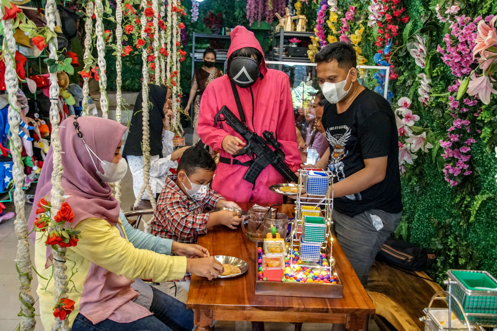 Pengunjung bermain permen dalgona ala film Squid Game di Strawberry Cafe di kawasan Duri Kepa, Jakarta Barat, Minggu, 17 Oktober 2021.