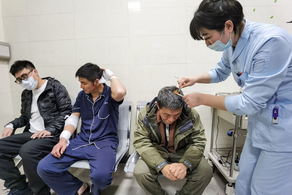 Seorang pekerja medis merawat seorang pasien di sebuah rumah sakit di Shenyang, provinsi Liaoning timur laut China pada 21 Oktober 2021, setelah ledakan gas di sebuah restoran dan menewaskan sedikitnya tiga orang dan melukai puluhan lainnya.