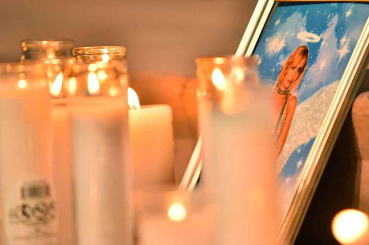 Lilin diletakkan di depan foto sinematografer Halyna Hutchins saat upacara penghormatan di Albuquerque Civic Plaza, Albuquerque, New Mexico, Sabtu, 23 Oktober 2021 waktu setmpat.