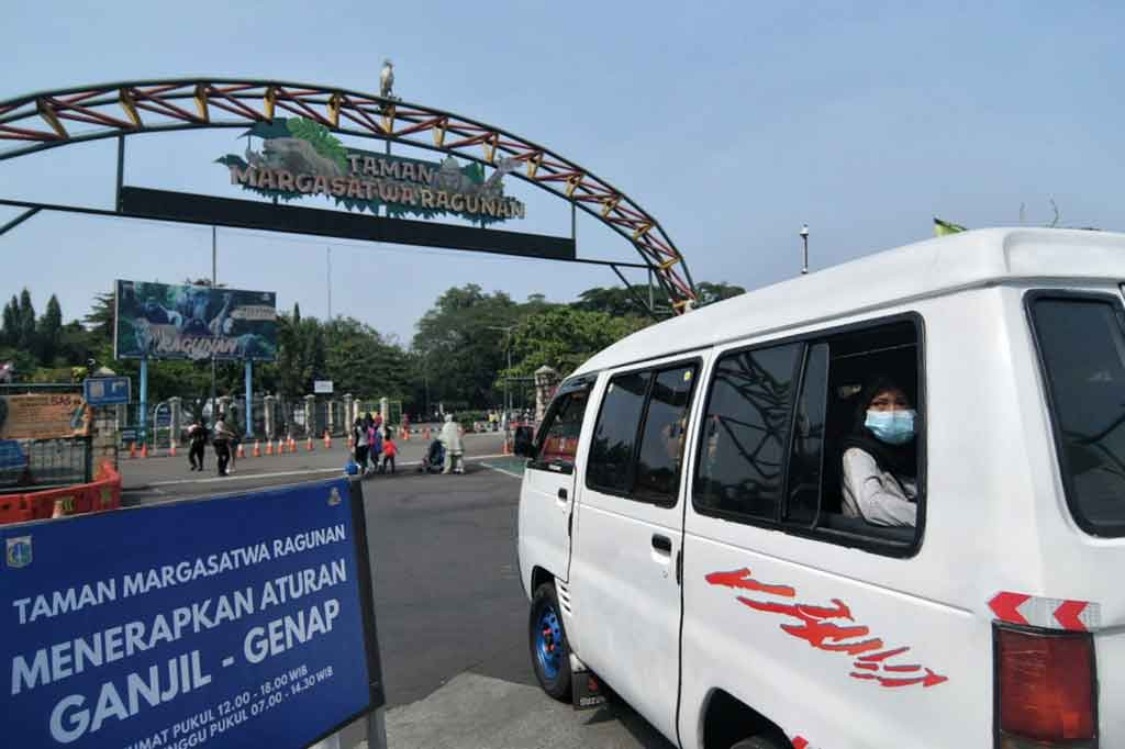 Plang bertuliskan aturan ganjil genap terpampang di pintu  masuk kawasan Taman Margasatwa Ragunan, Jakarta, Minggu, 24 Oktober 2021. 