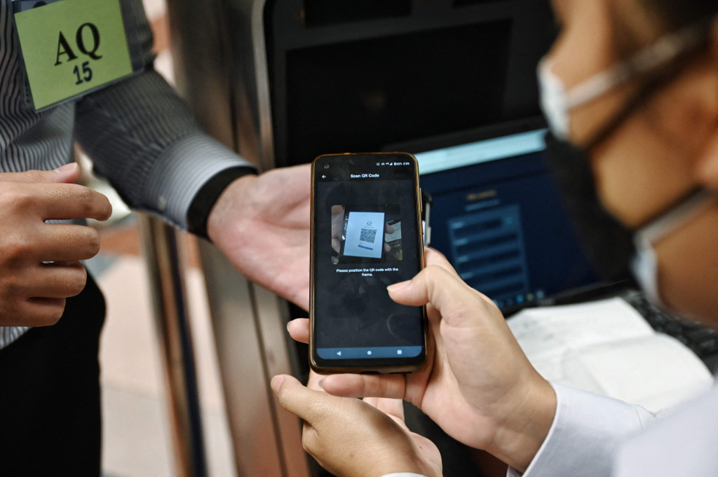Petugas menggunakan kode QR untuk memasuki jalur masuk baru di Bandara Internasional Suvarnabhumi saat mereka berlatih prosedur untuk pembukaan kembali Thailand, di Bangkok, Rabu, 27 Oktober 2021.