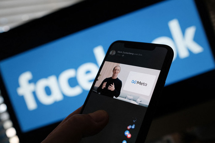 Seseorang menonton di smartphone saat CEO Facebook Mark Zuckerberg mengumumkan perubahan nama perusahaan induknya menjadi Meta.