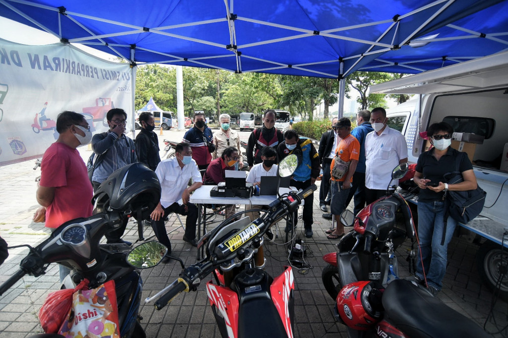 Warga saat menunggu kendaraannya dilakukan uji emisi gas buang kendaraan di Lapangan Parkir IRTI Monas, Jakarta, Rabu, 3 November 2021. 