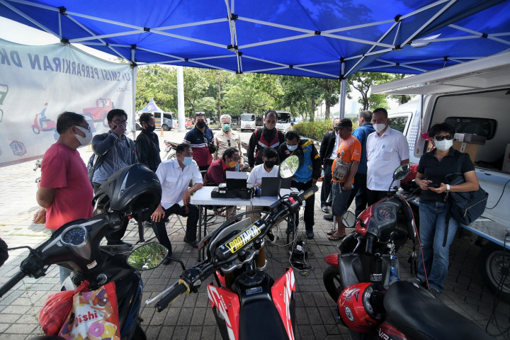 Warga saat menunggu kendaraannya dilakukan uji emisi gas buang kendaraan di Lapangan Parkir IRTI Monas, Jakarta, Rabu, 3 November 2021. 