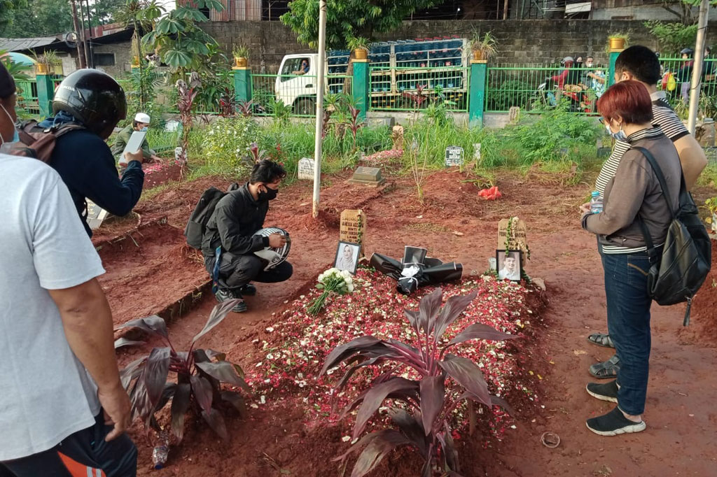 Sementara warga lainnya mengabadikan kerabatnya saat berdoa.