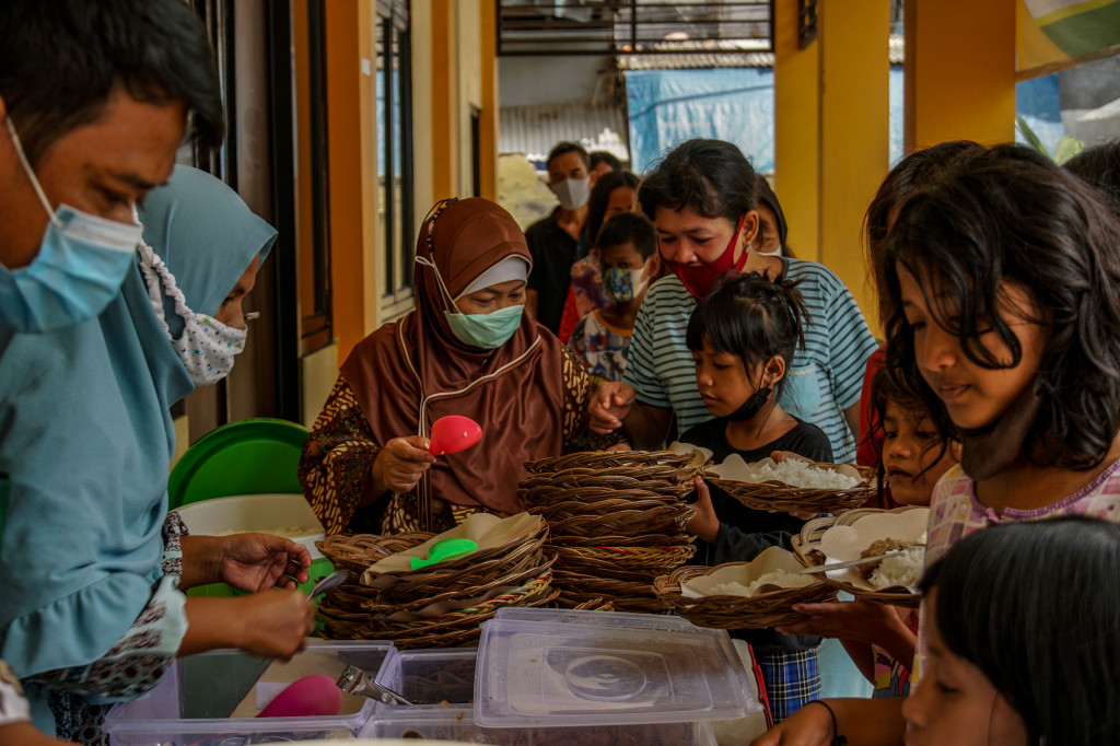 Sejumlah warga antre makanan gratis di Warung Ikhlas di kawasan Pademangan Timur, Jakarta Utara, Senin, 8 November 2021.