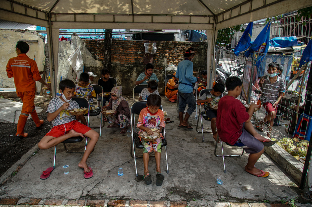 Warga menyantap makanan gratis di Warung Ikhlas di kawasan Pademangan Timur, Jakarta Utara, Senin, 8 November 2021.