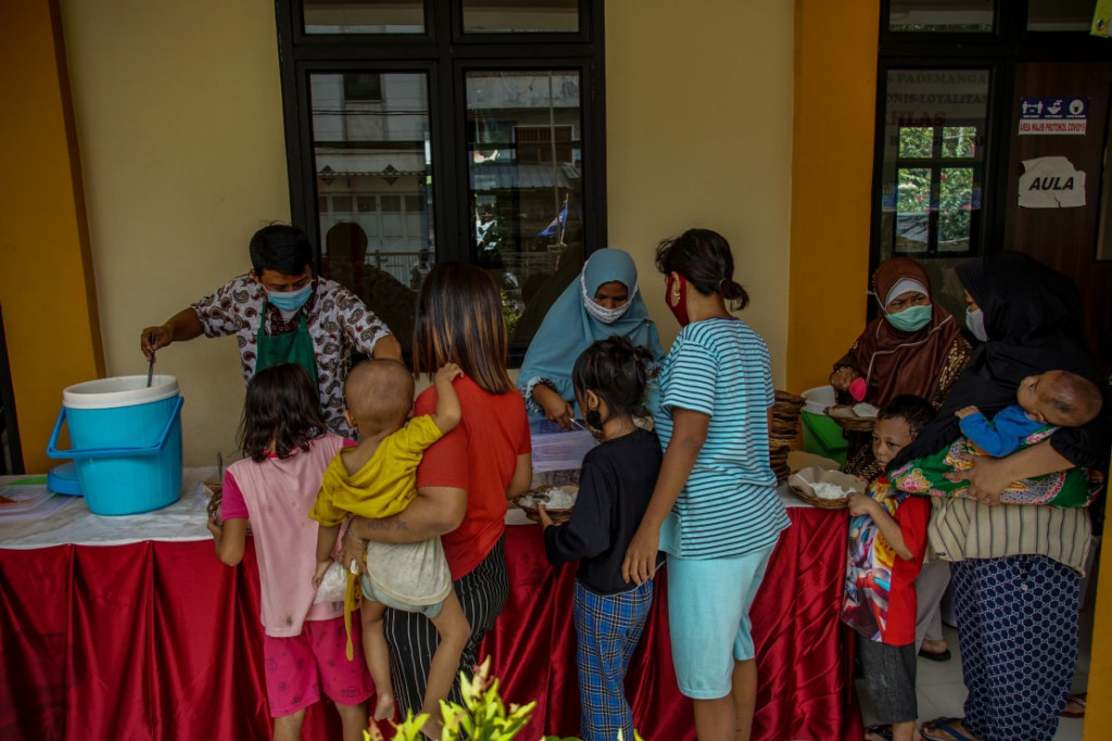 Sejumlah warga antre makanan gratis di Warung Ikhlas di kawasan Pademangan Timur, Jakarta Utara, Senin, 8 November 2021.