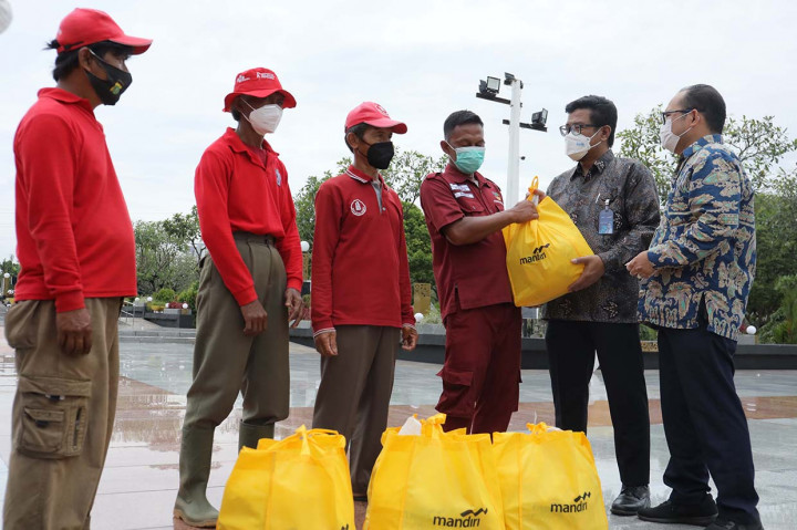 VP Strategic Planning & Budgeting Bank Mandiri Satryo Widiarto (dua kanani) dan AVP CSR Dept Bank Mandiri Mashuri (kanan) menyerahkan paket sembako kepada petugas Taman Makam Pahlawan (TMP) Kalibata dalam menyambut Hari Pahlawan di Jakarta, Rabu, 10 November 2021. 