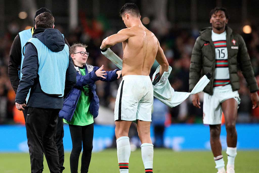 Superstar Timnas Portugal dan Manchester United Cristiano Ronaldo membuat gembira penggemar kecil tim lawan yang berlari ke lapangan di Stadion Aviva tepat setelah peluit panjang dibunyikan tanda laga Rep Irlandia vs Portugal dalam kualifikasi Piala Dunia 2022 selesai. Kedua tim bermain imbang 0-0.