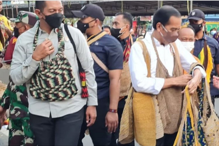Mama-mama penjual pun sangat senang saat dagangannya diborong oleh Presiden Jokowi. Apalagi rombongan Presiden termasuk anggota Paspampres juga ikut membeli noken dan langsung memakainya.