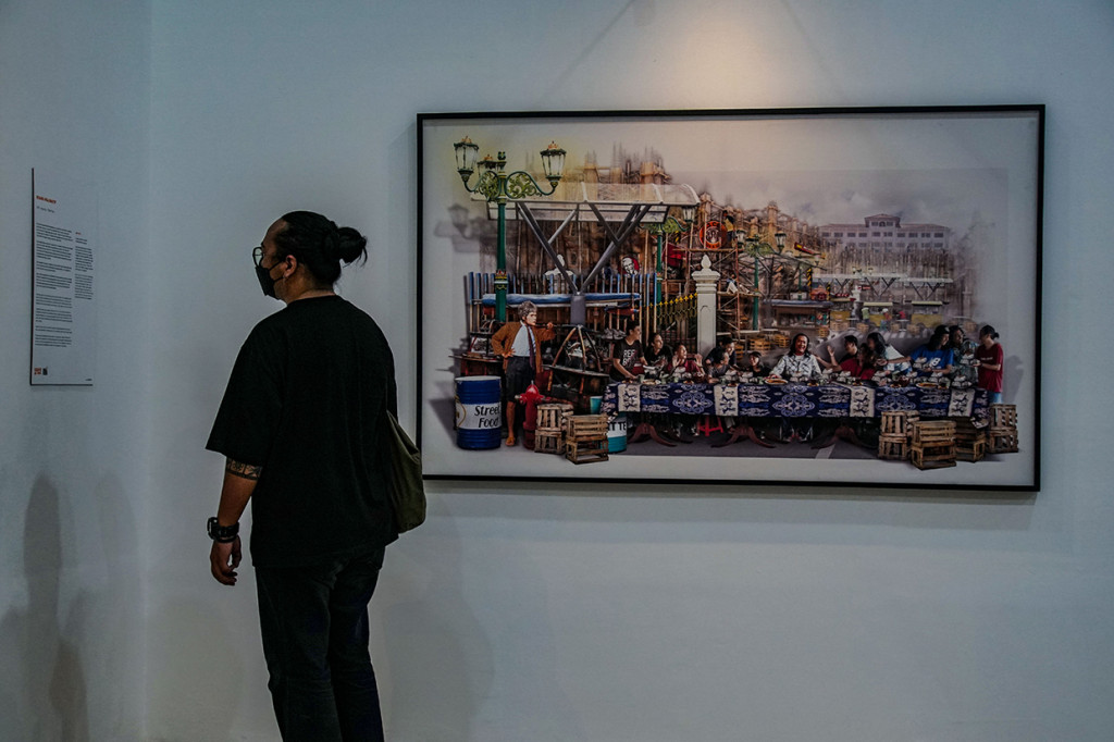 Pengunjung melihat karya foto yang dipamerkan di Jakarta International Photo Festival (JIPFest) 2021 di Kota Tua, Jakarta, Minggu, 14 November 2021.