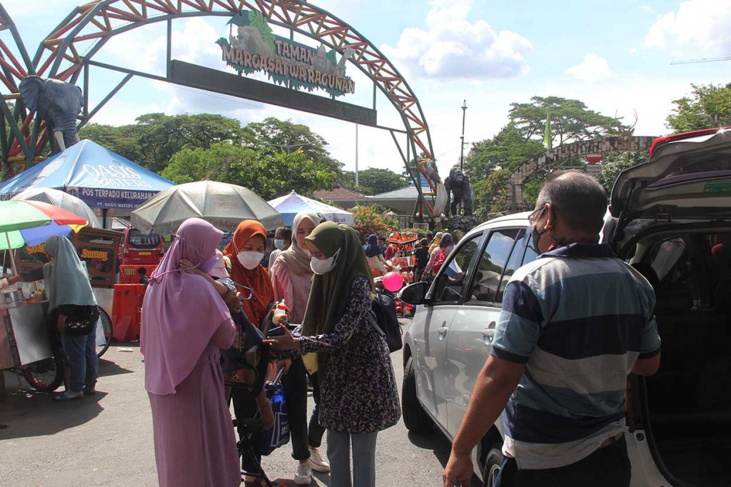 Warga masyarakat yang mengisi waktu liburannya saat akan masuk objek wisata Taman Margasatwa Ragunan di Pintu Masuk Taman Margasatwa Ragunan, Jakarta, Minggu, 14 November 2021. 