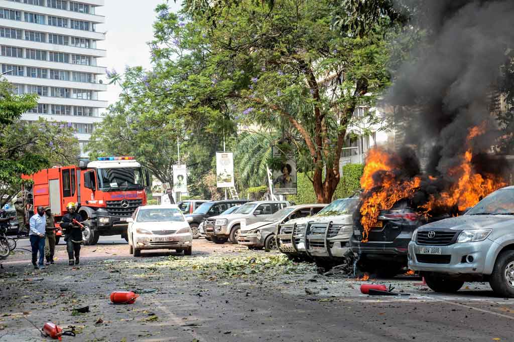 Polisi menyatakan bahwa dua pengebom bunuh diri dengan sepeda motor - menyamar sebagai pengemudi ojek lokal 'boda boda' - meledakkan sebuah alat di dekat pintu masuk parlemen, menewaskan seorang pejalan kaki. 