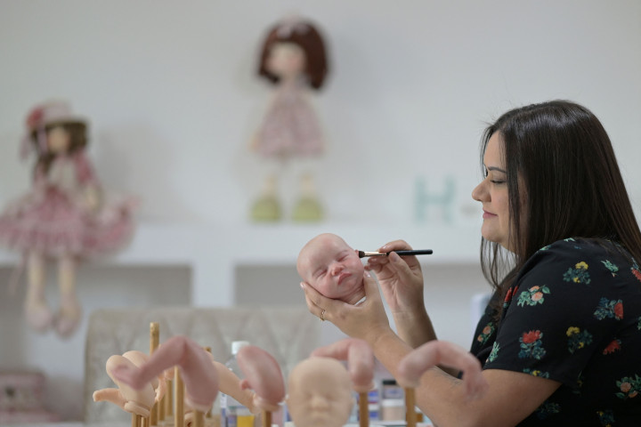 Seniman Brasil Ana Paula Guimaraes menyelesaikan pembuatan boneka bayi super realistis di studionya di Contagem, Brasil, pada 16 November 2021.