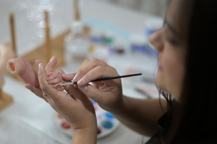 Seniman Brasil Ana Paula Guimaraes menyelesaikan pembuatan boneka bayi super realistis di studionya di Contagem, Brasil, pada 16 November 2021.