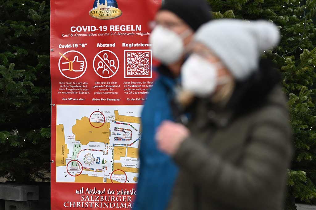 Sebuah poster menampilkan aturan bagi pengunjung pasar natal di tengah pandemi covid-19 baru di Salzburg, pada Jumat, 19 November 2021.