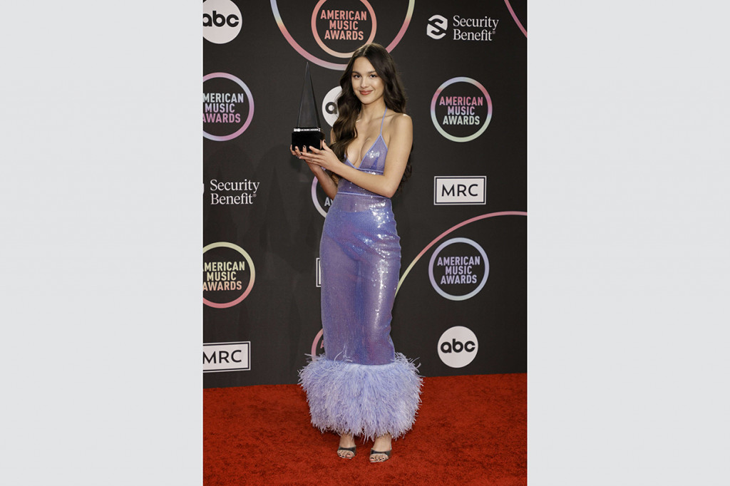 Penyanyi berusia 18 tahun ini cukup berani mengenakan gaun metalik serta strap heels sebagai penyeimbang gaya. 