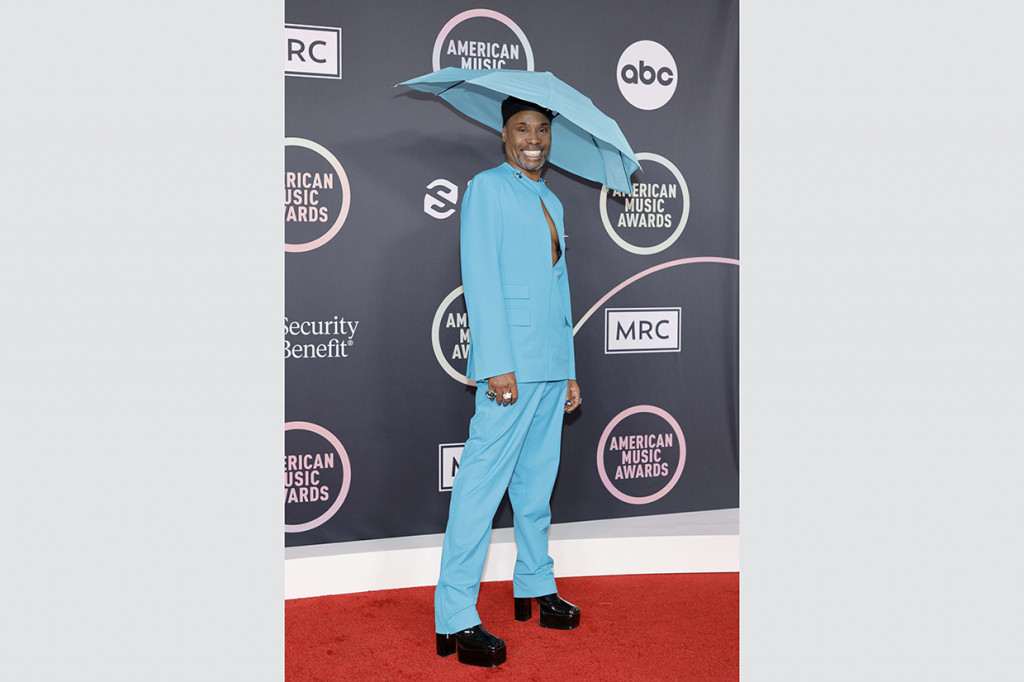 Billy Porter. Aktor kawakan ini kembali menghiasi daftar outfit terbaik. Billy berpose di red carpet AMAs 2021 mengenakan setelan jas blazer unik warna biru elektrik dari Botter lengkap dengan payung mini sebagai headpiece.