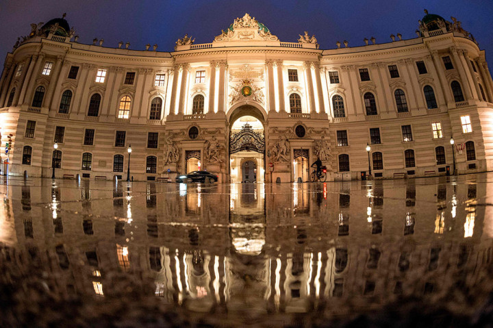 Seorang pengendara sepeda melewati Istana Hofburg di alun-alun Michaeler di Wina, Austria yang tampak sepi pada Senin, 22 November 2021 waktu setempat. 